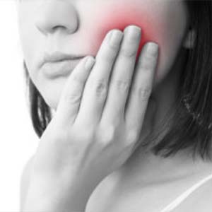 Young Woman Holding the Side of Her Face in Pain