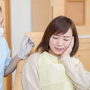 Young Woman Holding the Side of Her Face in Pain