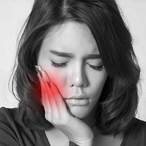 Young Woman Holding the Side of Her Face in Pain