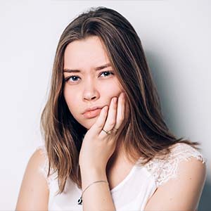 Young Woman Holding the Side of Her Face in Pain