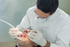 dentist doing a hygienical treatment to a 40 yearsold patient